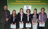 Region 8 Science Fair at Southeastern Louisiana University, Navy representative Joel Newcomb presents the Navy Science Achievement Award to Elise Frost, Sophie Giberga and Michelle Lawrence of St. Scholastica Academy, Hannah Pittman of Franklinton Jr. High, and Robin Spiess of Monteleone Junior High.