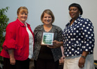 Nursing instructor Lindsay Dominano, center, presents award to LSUHSC’s Connie Liuzza, director of nursing, left, and Sherre Pack-Hookfin, administrator.