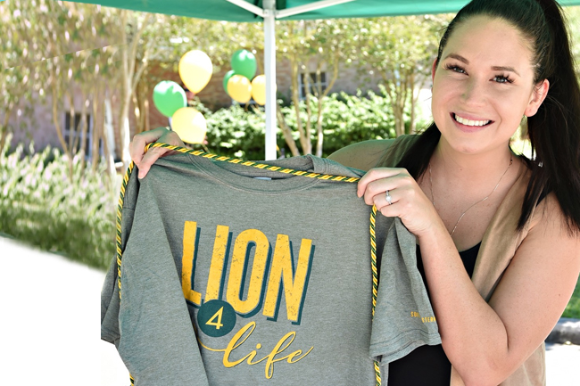 Girl holding Lion Legacy donation items.