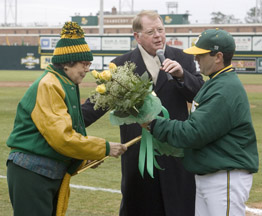 President Moffett and Coach Artigues present roses to Mrs. Kenelly