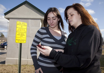 Southeastern students Rachel Domiano, left, and Maggie Rownd, check the location of the next shuttle bus.
