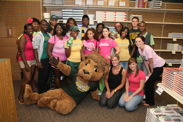 Southeastern mascot, Roomie, poses with models from the Texas Bookstore grand opening.