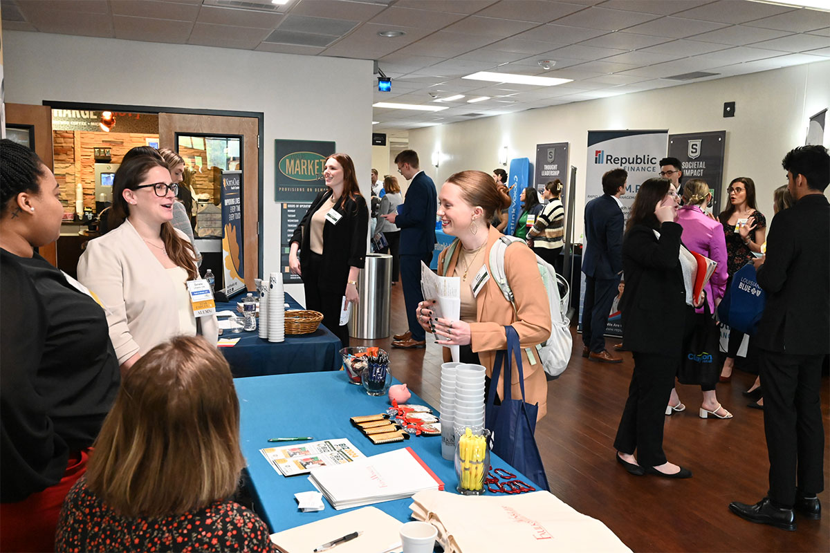 Student speaking with professionals at a career expo at Southeastern.