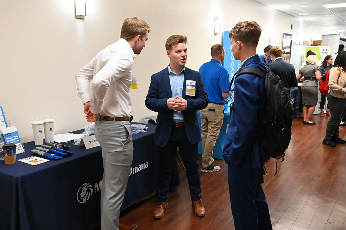 Student speaking with professionals at a career expo at Southeastern.