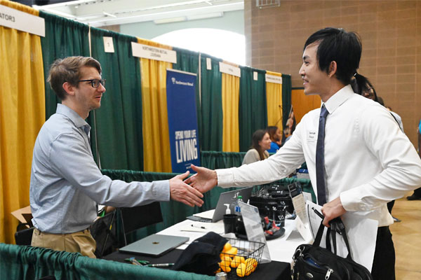 two men shaking hands at career fair