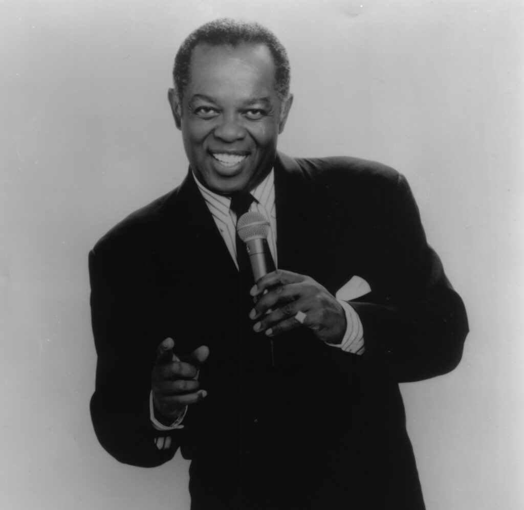 Singer Lou Rawls poses with his microphone.
