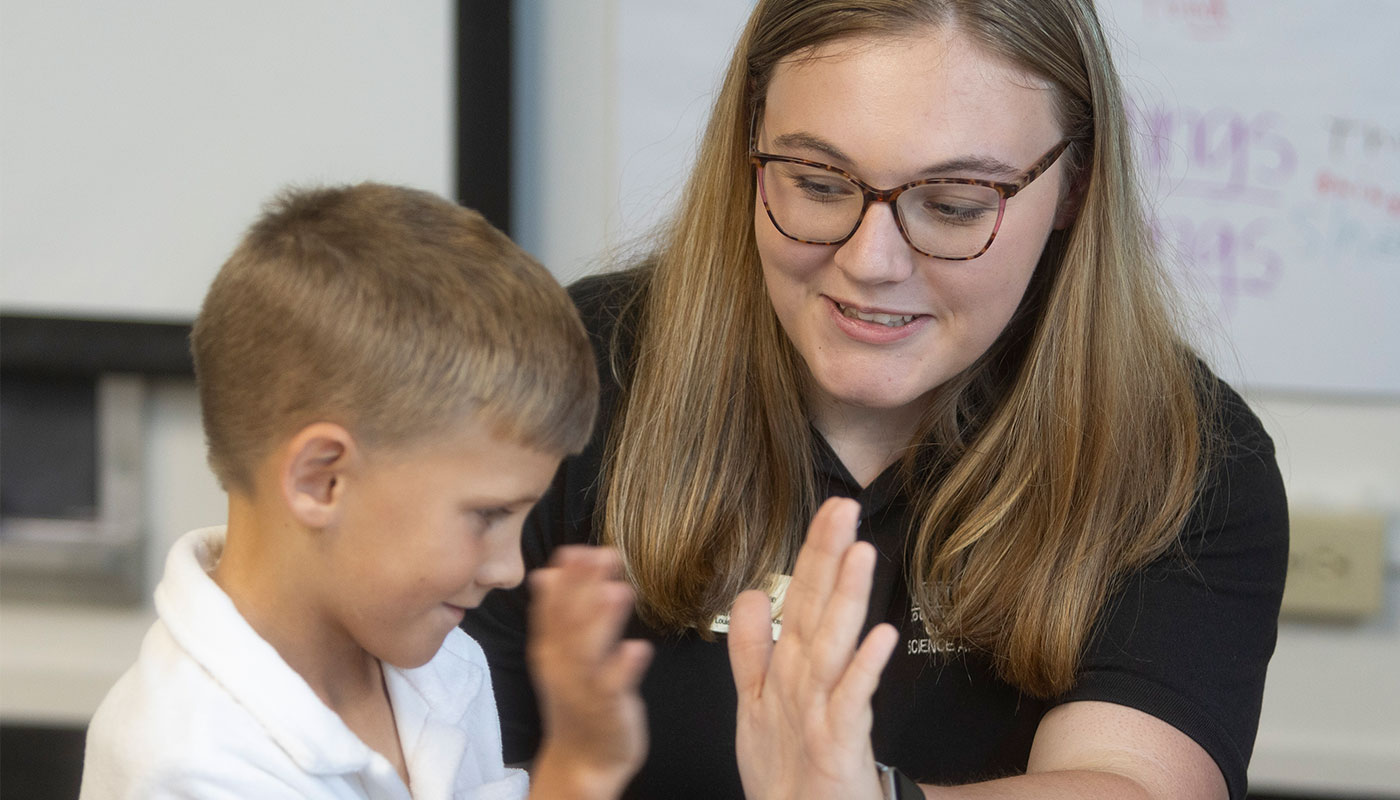 A child and a nursing student high-five