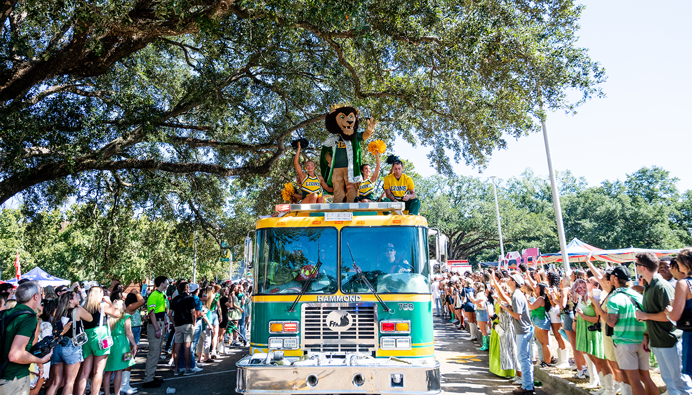 Roomie waving his arms to the crowd while on a fire truck.