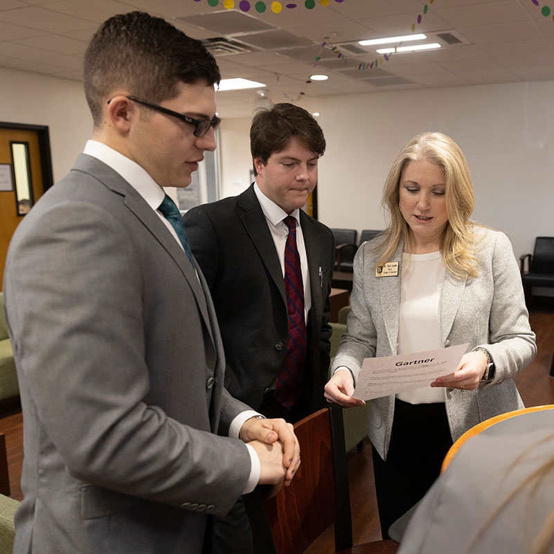 Dr. Tara Lopez, Dean of the College of Business speaking with two students.