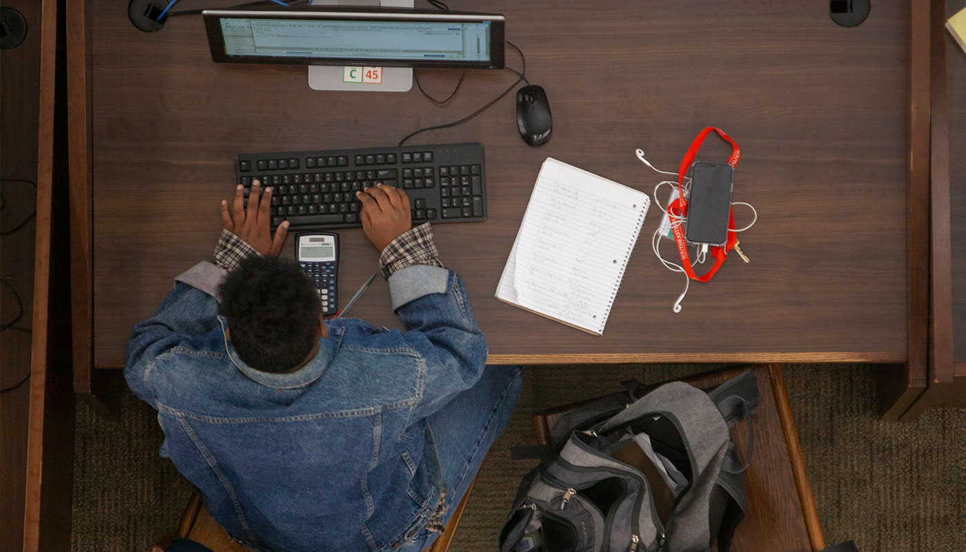 student at desktop computer in library