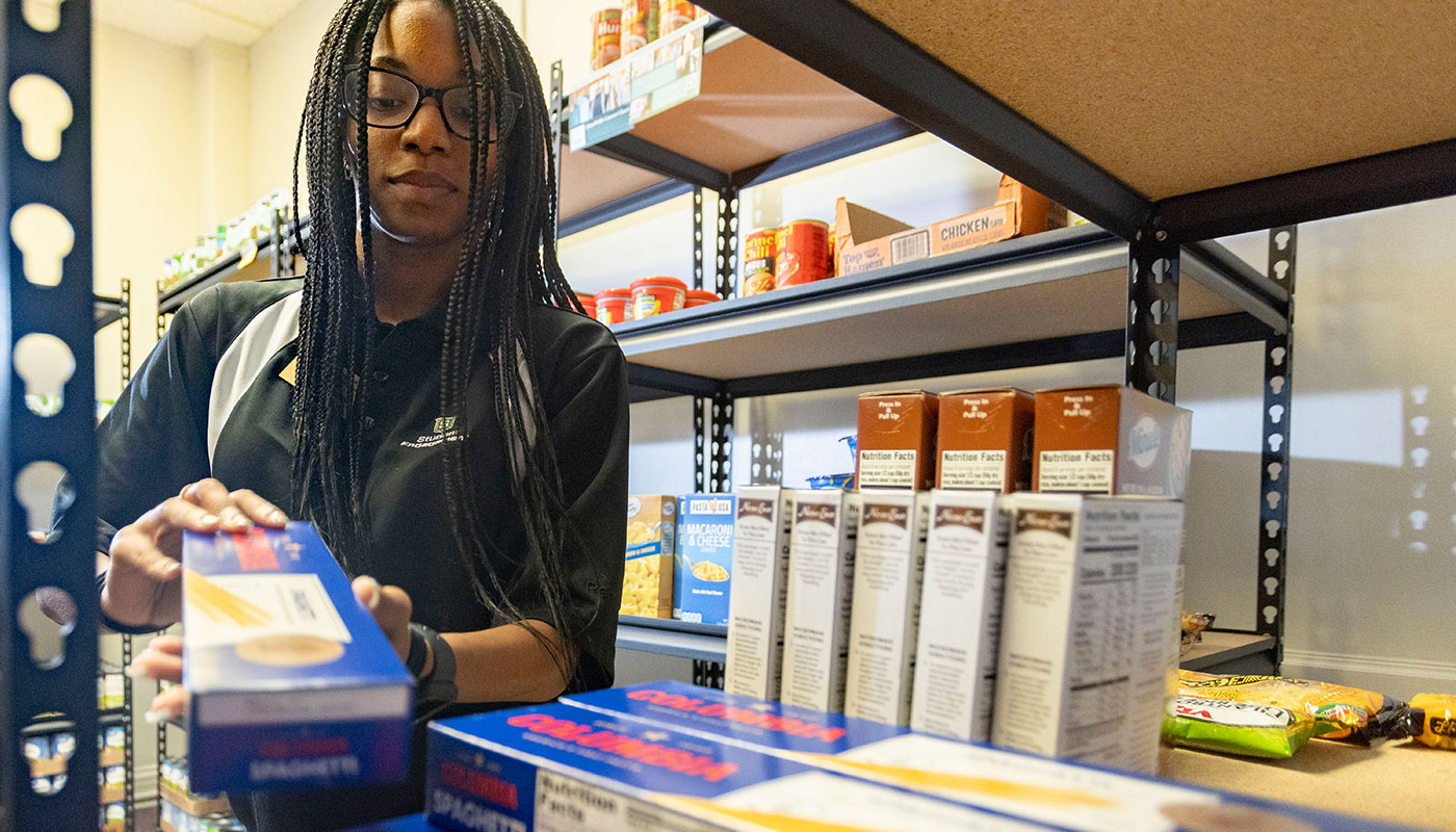 Student wroker restocking the food pantry