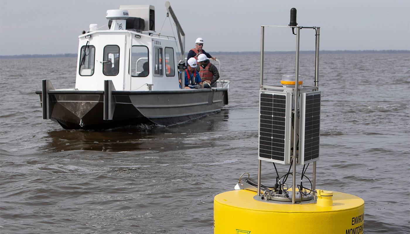 Scientists approach a monitoring buoy in the Manchac area.