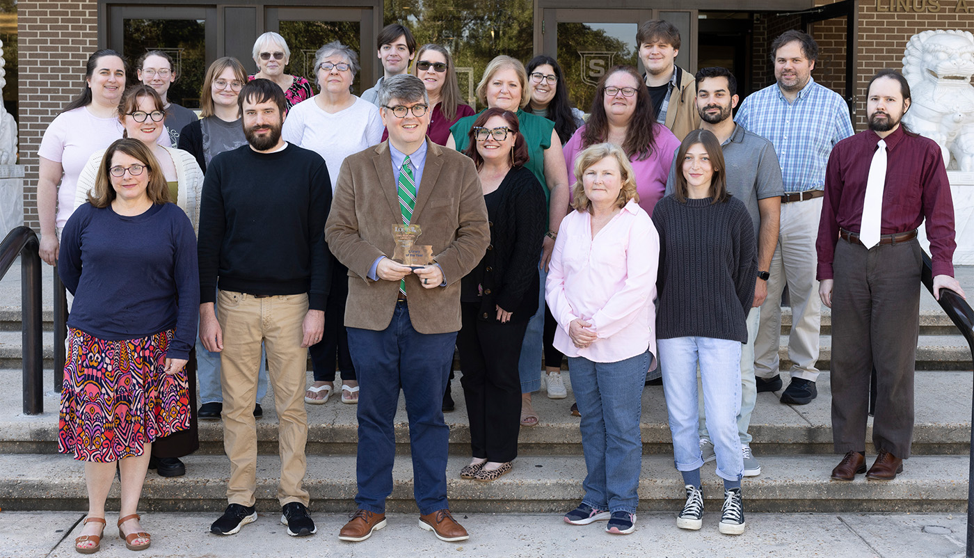 Sims Memorial Library staff pose in front of the library.
