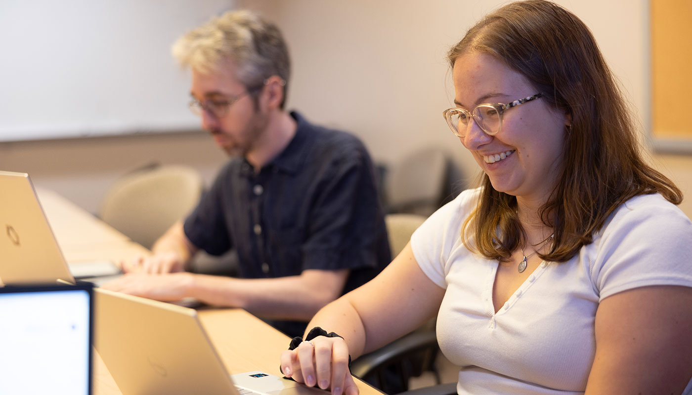 male and female students on laptops