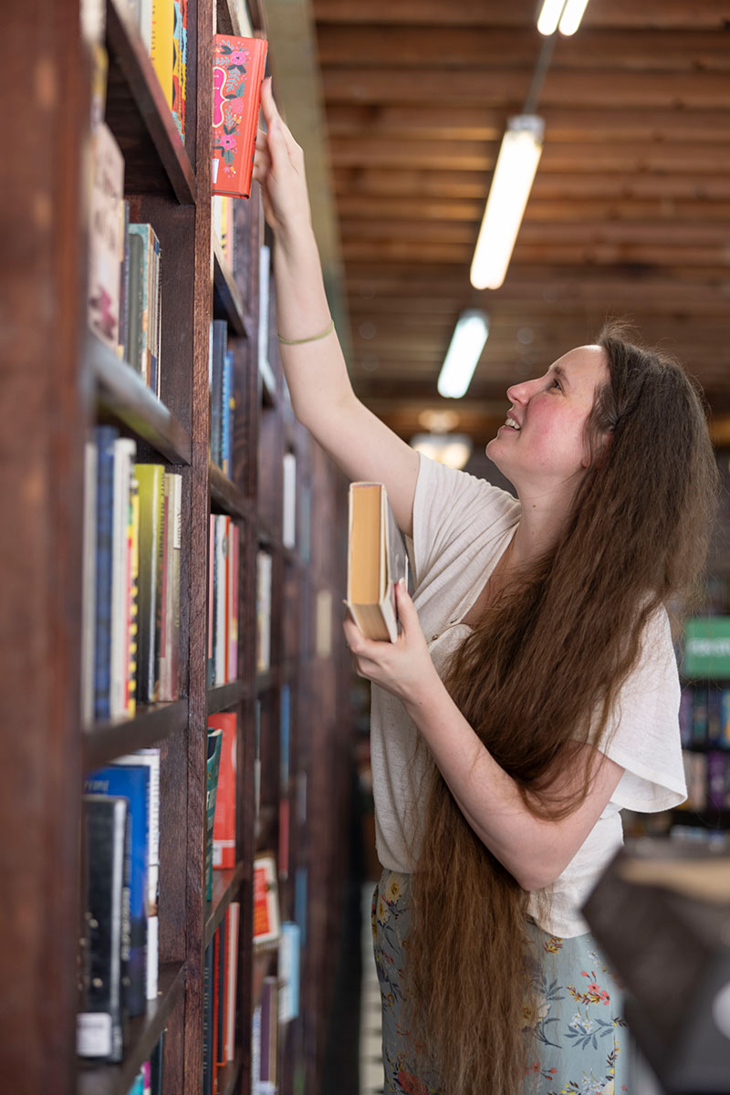 Michelle Cavalier placing books on shelves.