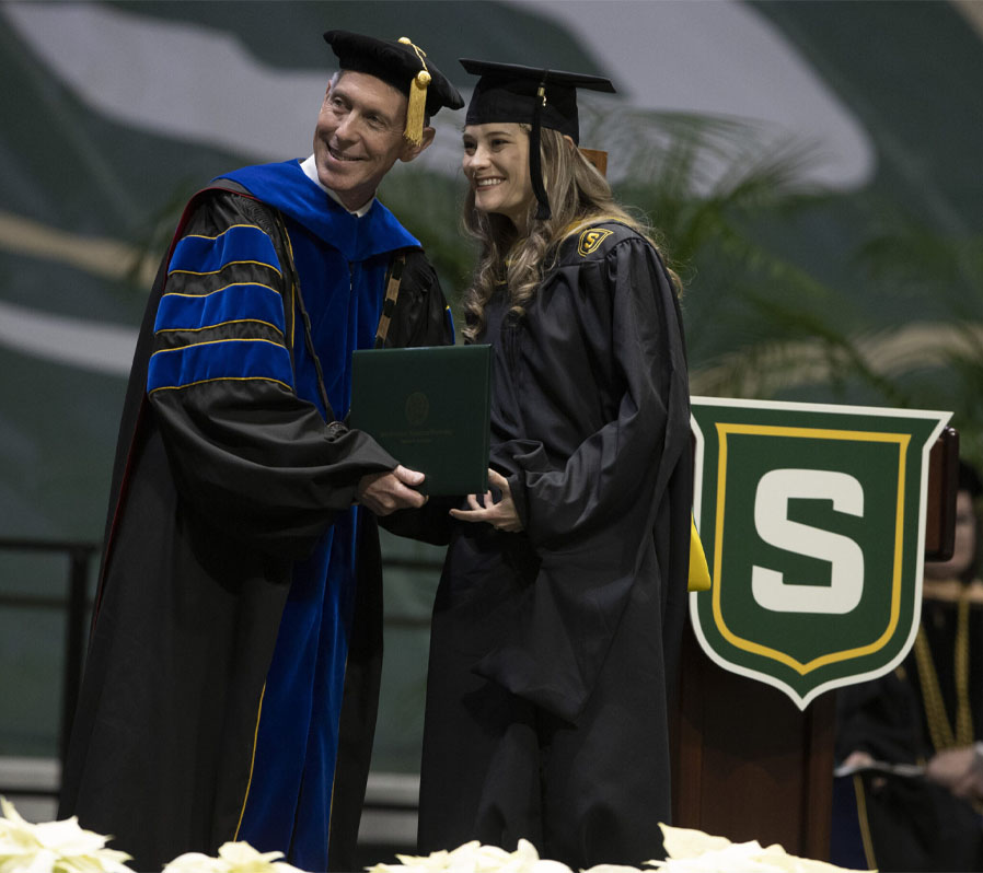 John Crain handing out diplomas at Commencement.