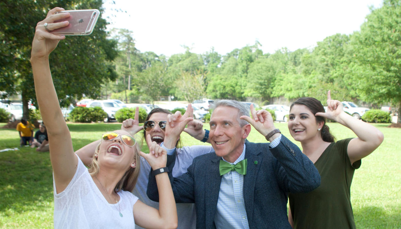 John Crain taking a selfie with students.