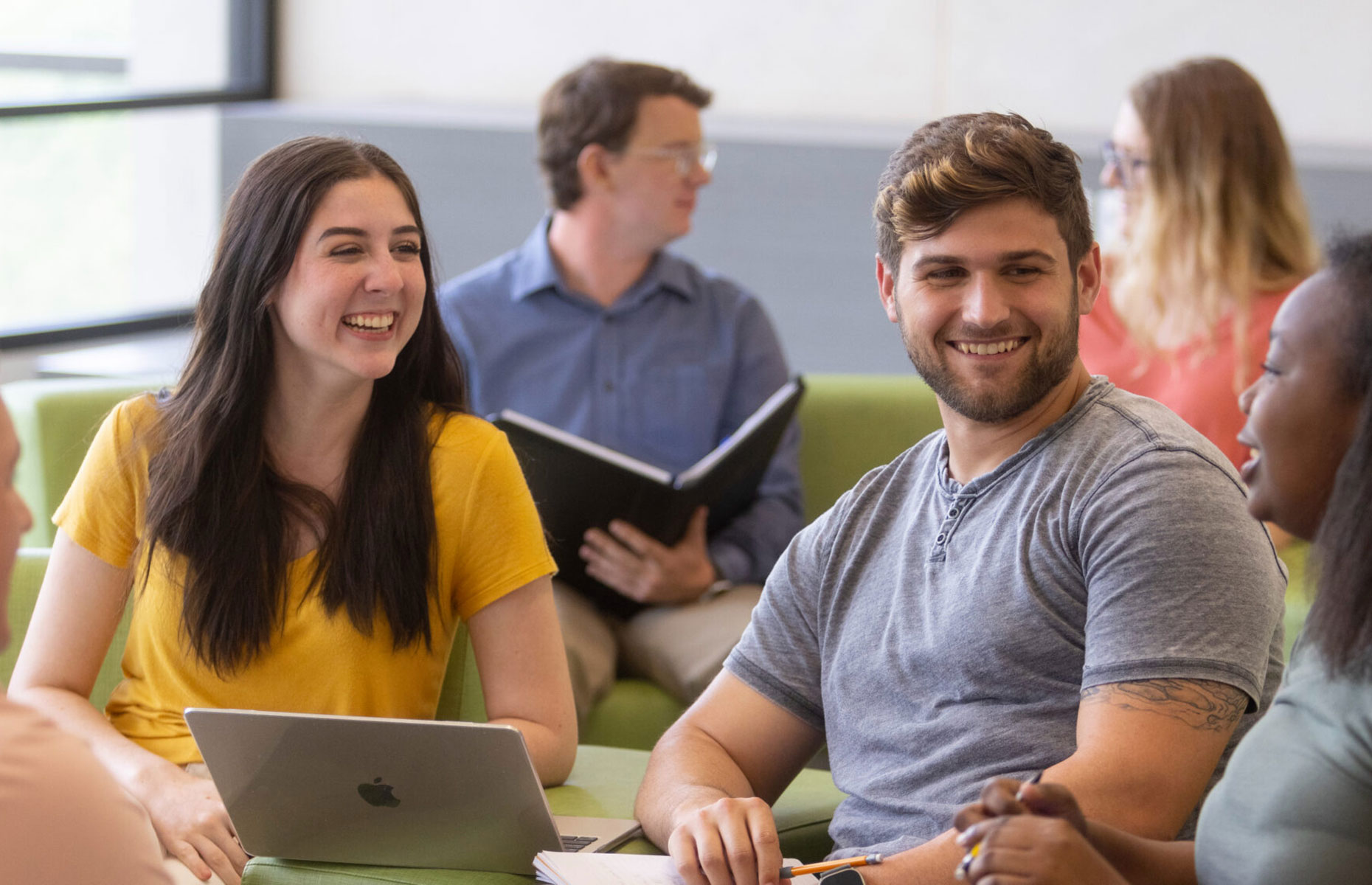 Students smiling and sitting together.