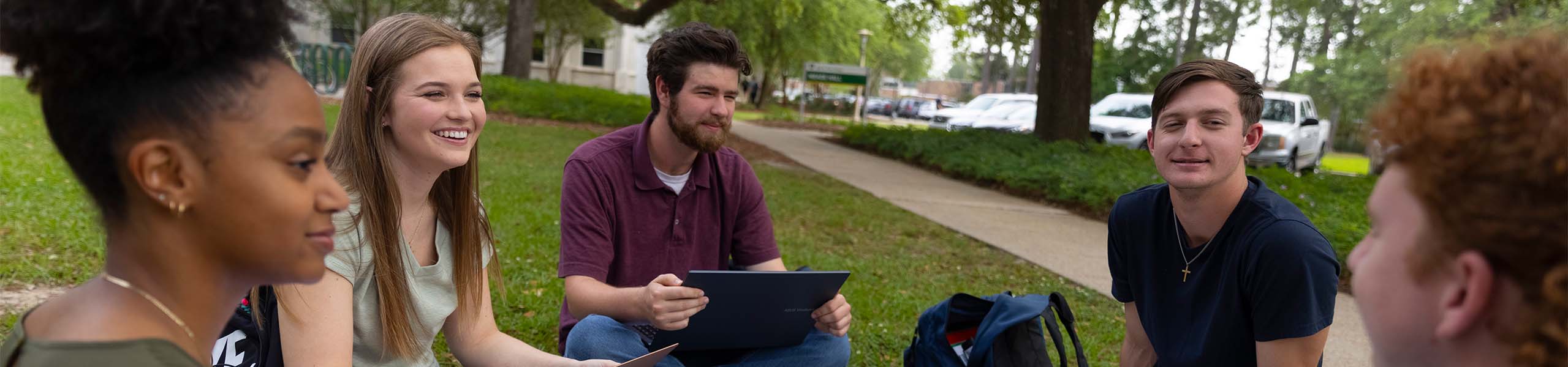 Students sitting outside talking.